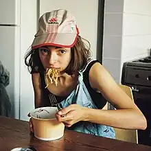 Stella Donnelly eating from a bowl of noodles.