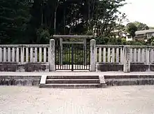 Torii behind concrete fence.