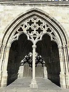 "Le porche du peuple" on the south side of the cathedral. The porch leads to a double-doored entrance to the cathedral and the side walls are decorated with statues of the Evangelists and others. Note the elaborate rosace at the top of the porch's supporting colonnette.