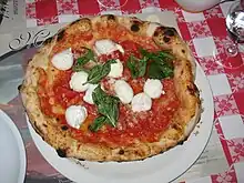 Image 10Traditional pizza Margherita, whose ingredients, tomato (red), mozzarella (white) and basil (green), are inspired by the colours of the national flag of Italy. (from Culture of Italy)