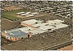 An aerial image of Tri-City Mall in Mesa, Arizona, showing the mall structure and its surrounding parking lot.