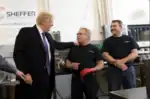 President Donald J. Trump prepares to sign a worker's hat while visiting with employees during his tour of the Sheffer Corporation, Monday, February 5, 2018, in Blue Ash, Ohio.