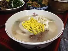 Tteokguk topped with egg garnish strips