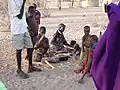 Turkana women pound palm nuts to remove husks. Inner nut is consumed as food.