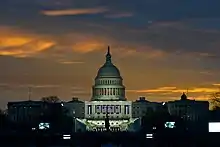 U.S. Capitol at dawn, mostly darkened but with the dome floodlit from without