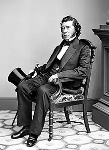 Studio portrait photo of Sen. Hamilton Fish seated position showing head and shoulders with top hat and cane held in right hand