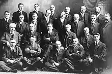 A large group of white men in suits posing for a picture