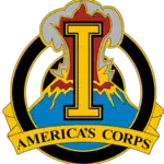 A gold device containing a gold letter I superimposed over an erupting volcano, with the words "America's Corps" at the bottom