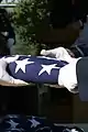 An Air Force honor guard folds the American flag after presenting it to the families of the first veterans buried.