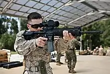 A U.S. Marine armed with an M27 IAR affixed with ACOG Squad Day Optic.