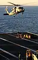 Sailors on the flight deck of Ronald Reagan stand by as an SH-60F Seahawk assigned to the Black Knights Helicopter Anti-Submarine Squadron 4 delivers cargo during a vertical replenishment.