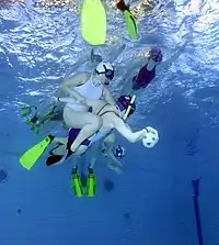 Underwater rugby players wearing water polo caps