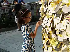 Girl inspects messages on a pillar