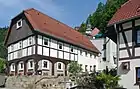 An Umgebindehaus in Oybin (Saxony). The timber frame is outside a log wall on the ground floor.