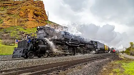 Two steam locomotives double heading and climbing a mountain range in Utah