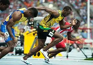 100m race record holder Usain Bolt (in yellow) and other runners in sportswear.