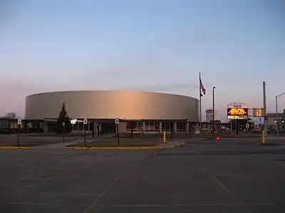 A brightly lit hockey arena, clad in metal panels.