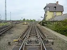 Image 17The "hump" of a hump yard. Railcars travel past retarders, which control their speed, and are directed onto tracks to be assembled into new trains. The control tower operates the retarders. (from Rail yard)