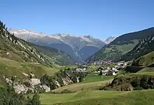 View over the lower reaches of the Rein da Medel, facing north. In the foreground Platta; in the background Curaglia. The ravine that the Rein da Medel has eroded into the bottom of the U-shaped glacial valley, is clearly visible.