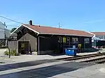 A single-story railroad building. Signs on the building identify it as property of the Providence and Worcester Railroad and mention a safety goal of no injuries.