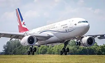 A gloss white painted Airbus A330 with a red, white and blue 'union jack' flag on its vertical tail fin, operated by the Royal Air Force, which has been modified for military and VIP use, is about to land RAF Brize Norton in Oxfordshire.