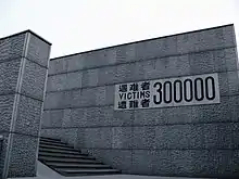 A wall at the entrance of the Memorial Hall, with the words "Victims 300,000" carved in stone