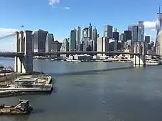 A photograph of the bridge from a similar angle as the lithograph, with the skyscrapers of Lower Manhattan in view