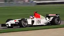 Jacques Villeneuve driving the BAR 005 with non-tobacco livery replaced with bar code and F1 cars at the 2003 United States Grand Prix.