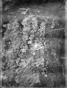 A photo taken from the air, plumes of smoke rise over a town.