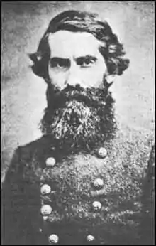 Black and white photo of a bearded man in a military uniform with two rows of buttons.