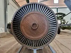 This rear view of a Klimov VK-1 turbojet shows the parts responsible for turbine temperature overshoot after increasing thrust from idle to take-off, known as transient EGT overshoot. Visible is the turbine blade tip clearance which is a leakage path for gas which doesn't contribute to the power developed by the turbine. Increased gap, and leakage, means more fuel, indicated by a higher EGT, is required to get take-off thrust. Clearance is increased temporarily every time the engine goes from idle to take-off because the light casing expands quickly to the turbine gas temperature but the heavy turbine rotor takes minutes to expand to its hot diameter.