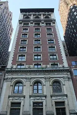 The facade of the Engineers' Club Building, which consists of a granite facade on the lowest stories and a brick facade above.