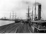 Wallaroo jetty in 1909, showing shipping, launches, and grain waiting for loading.