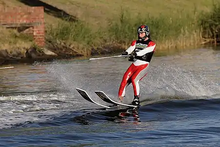 Image 3WaterskiingPhoto: Fir0002A man engaged in waterskiing, a sport in which an individual is pulled behind a boat or a cable ski installation on a body of water, skimming the surface. Waterskiing is a relatively young sport, having been invented in the early 20th century. The skis this person is wearing are specialized for ski jumping.More selected pictures