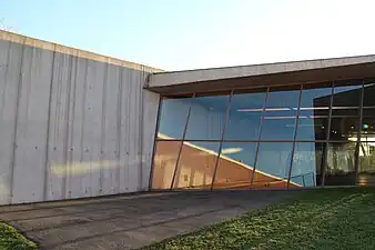 A view of the art gallery space behind the window. The reflection of other buildings in the Vitra Fire Station give a small sense of the other Vitra campus buildings.