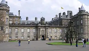 View of the Palace of Holyrood House showing the Royal Banner of Scotland flying from the rooftop flagpole, indicating that Her Majesty the Queen is not in residence.