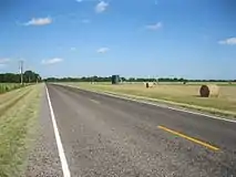 Baled hay and oil tanks can be seen along the eastern portion of FM 961.