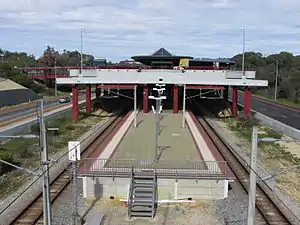 Large concrete structure with buses over island platform