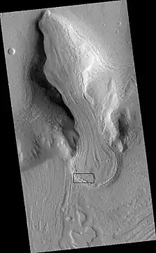 Glacier as seen by HiRISE under the HiWish program.  Area in rectangle is enlarged in the next photo.  Zone of accumulation of snow at the top.  Glacier is moving down valley, then spreading out on plain.  Evidence for flow comes from the many lines on surface.  Location is in Protonilus Mensae in Ismenius Lacus quadrangle.