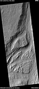 Streamlined feature in Mangala Vallis, as seen by HiRISE under HiWish program.  Many dark slope streaks are visible.  Location is Memnonia quadrangle.