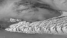 Defrosting dunes in Von Karman Crater, as seen by CTX camera (on Mars Reconnaissance Orbiter).   Dark places are where frost has left dark dunes.  Picture taken in the springtime on Mars.