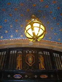 The central section of the lobby. Ornate metalwork is visible in the lower part of the image, while a globe hangs from a blue-and-gold ceiling at the top.