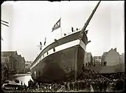 The launch in 1892 of a ship built on the Oostenburgervoorstraat. To the left are warehouses on Wittenburg.