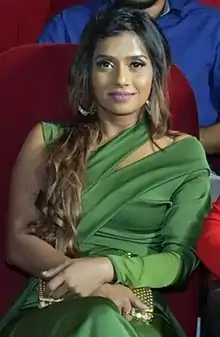 Zeenath Abbas looking at the camera smiling wearing a green dress