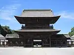 Two-storied wooden gate with a hip-and-gable roof and a passage in the central bay.